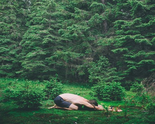 man doing yoga outdoors in nature